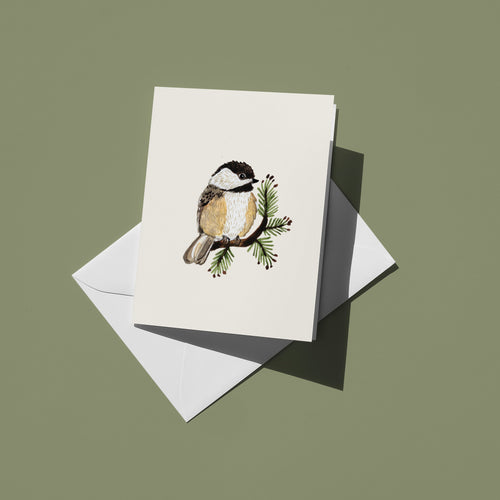 Greeting card with a chickadee illustration on a white envelope against a green background